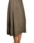 khaki nylon midi skirt with front pleats, drawstring waistband, and hidden side pockets, styled with a black top and woven sandals